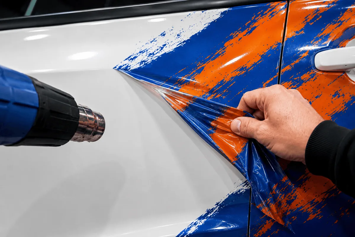Vinyl being peeled from a vehicle panel